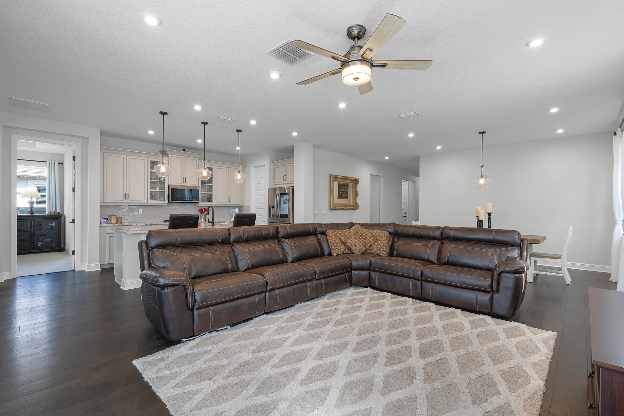 living room with beige area rug and brown sectional